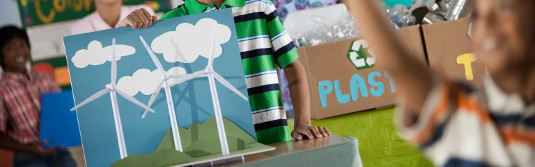kids showing sustainability cardbaords they prepared